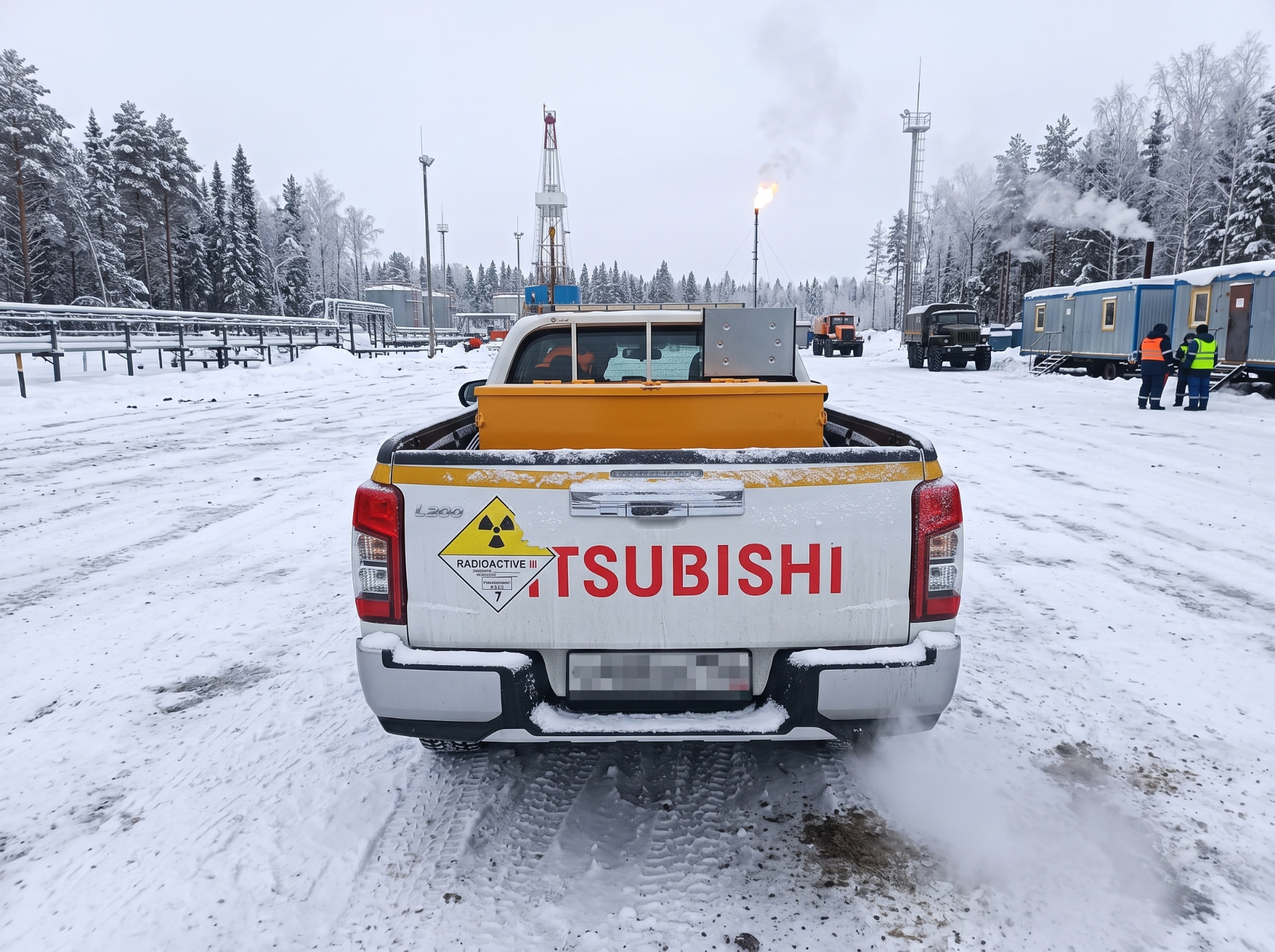 Mitsubishi L200 со знаком опасности «РАДИОАКТИВНОЕ» класса 7 на промысле зимой
